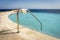 Summer vacation and swimming concept with a empty infinity pool and a life buoy overlooking the caribbean sea during a sunny day