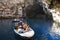 During summer vacation tourists make an excursion in the boats on the lake of Melissani Cave located on the island of Kefalonia,