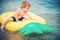 Summer vacation and travel to ocean. Small boy child sunbath on air mattress. Pineapple inflatable mattress, activity