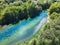 Summer vacation on a winding forest river. People are paddling in the blue water