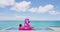 Summer Vacation Woman in bikini on inflatable pink flamingo toy mattress in pool