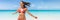 Summer vacation woman happy running on beach enjoying holidays travel. Banner panorama crop with ocean copyspace