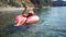 Summer vacation woman in hat floats on an inflatable donut mattress. Happy woman relaxing and enjoying family summer