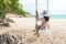 Summer Vacations. Lifestyle women relaxing and enjoying swing on the sand beach, fashion stunning women on the tropical island so