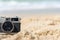 Summer Vacations. Vintage old camera of tourism on sandy beach.