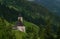 Summer valley with Grossarler Ache small river and blue cloudy sky and church