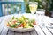 summer vibe: chilled greek salad on a sunny patio table