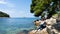 Summer vibes girl portrait. Young pretty woman looking on the adriatic sea, sitting on cliff. Travel concept. Red head pony tail