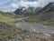 Summer view of alpine mountain valley with winding stream and glacial lake, Sulzenauferner Glacier, Stubai Alps, Austria