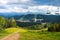 Summer view of Carpathian Mountains landscape in Bukovel, Ukraine. Green forests, hills, grassy meadows and blue sky