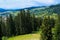 Summer view of Carpathian Mountains landscapevillage Vorohta Ukraine. Green forests, hills, grassy meadows and blue sky
