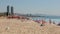 Summer view of lively popular Barceloneta beach with two modern skyscrapers rising in background on sunny day