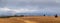 Summer view of the plowed field and mountains in are far at a partly cloudy.