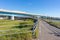 Summer view of small road and large highway bridge over the Tedori RIver, at Mikawa, Japan