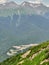 Summer view from the top of the mountain ridge at the ski resort, surrounded by high mountains