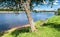 Summer view of the water surface and shores of the Volga river and the old Volga bridge in the background, city of Tver, Russia.