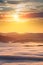 Summer weather phenomenon. Seasonal landscape with morning fog in valley. Clouds drenched valley below the level of the mountains.