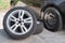 Summer wheels lying near car on winter tires