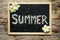 SUMMER word made from colorful gravel on black chalk board