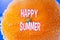 Summer with the words Happy Summer inscribed over a vibrant, juicy slice of orange, symbolizing the seasonal.