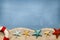 Summertime background - lifebuoy, beach sand and seashells
