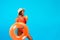 Summertime chill. Cool black woman in swimwear holding inflatable ring and drinking fruit cocktail on blue background