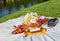 Summertime eco picnic setting on the grass with croissant, peaches, berries and wine on tablecloth