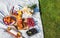 Summertime eco picnic setting on the grass with croissant, peaches, berries and wine on white tablecloth