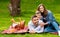 Summertime family activities. Joyful parents with son enjoying their picnic outdoors, copy space