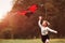 Summertime happiness. Cute girl in casual clothes running with kite in the field. Beautiful nature