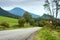 Summertime landscape - view of the road with slope warning sign against the background of mountains Western Carpathians