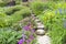 Summertime lush cottage garden with stone path