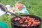 Summertime picnic in the courtyard - Cooking chicken wings on a round grill close up