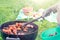 Summertime picnic in the courtyard - Cooking chicken wings on a round grill close up