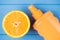 Summertime relax concept. Top above overhead view photo of orange slice and spf sunscreen isolated on blue wooden background