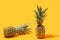 Summery funky optimistic two pineapples arrangement. Modern exotic vibe on vibrant yellow background