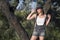 Summery photo of a woman posing in a short dress and a hat next to an oak tree