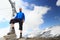 Summit cross and male mountaineer on mountain Weissspitze with Grossvenediger glacier panorama in Hohe Tauern Alps