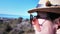 Summit Gaze: Close-up of Stylish Woman in Sunglasses Standing atop a Peak