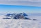 Summits of the Swiss Alps rising from a sea of fog in winter