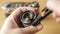 SUMY, UKRAINE - MAR 09, 2018: Closeup of photographer`s hands clean the old vintage lens at an angle with the help of a
