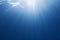 Sun beams shinning underwater . Trendy color classic blue background