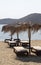 Sun beds and parasols on the beach at the beautiful Greek island of Ios.