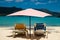 Sun beds under pastel colored umbrella on caribbean beach