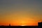 Sun below the horizon and the roof of the church with a cross, television antenna in the background fiery dramatic