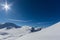 Sun and blue sky over Sandhubel mountain near Arosa in winter landscape