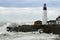 Sun Breaks Through Storm Clouds as Waves Crash By Maine Lighthouse