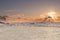 The sun bursts from behind a cloud over the frozen landscape of