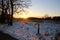 The sun casts a reddish glow in the snow