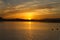 Sun cresting the horizon over a lake